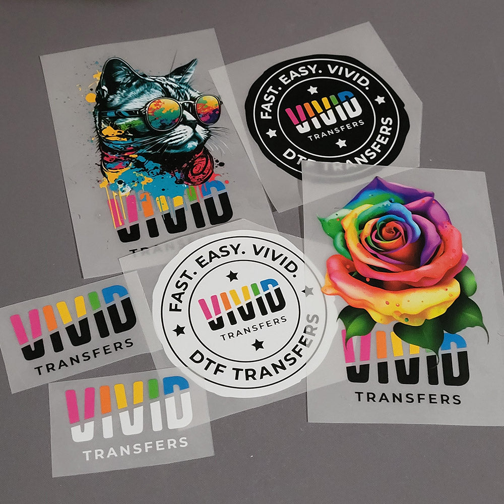 Colorful DTF transfers with a cat and rose design on a gray background