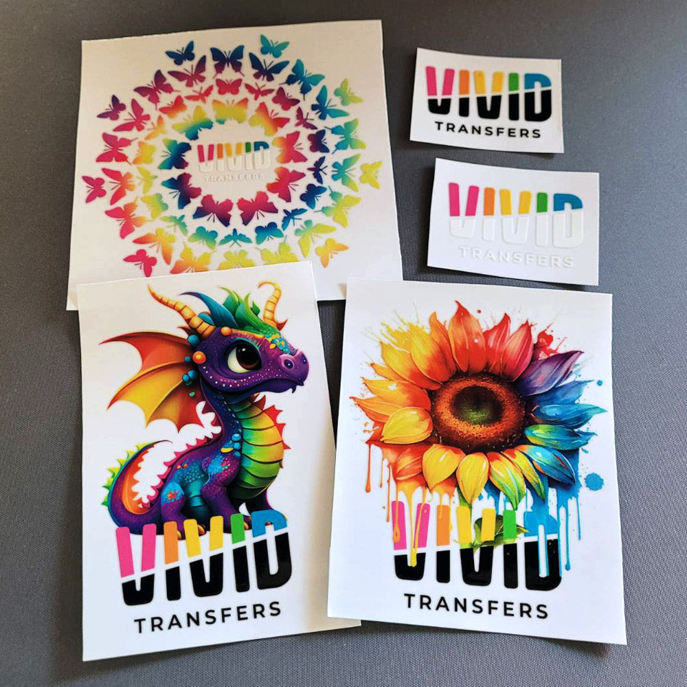 A range of UV DTF Stickers that come in a Vivid Transfers Sample pack sitting on grey surface